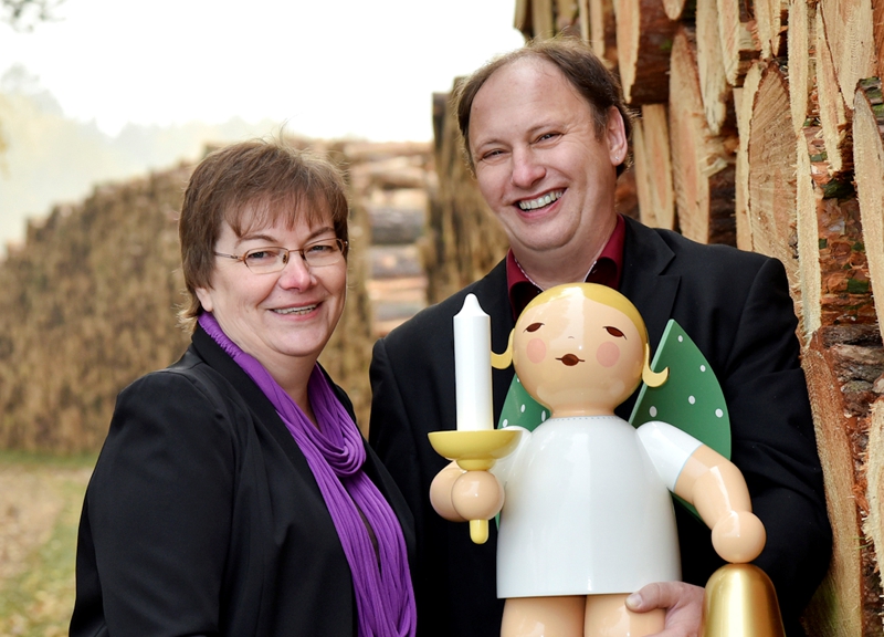 Herr und Frau Münnich vor einem Holzhaufen mit großem Wendt und Kühn Engel